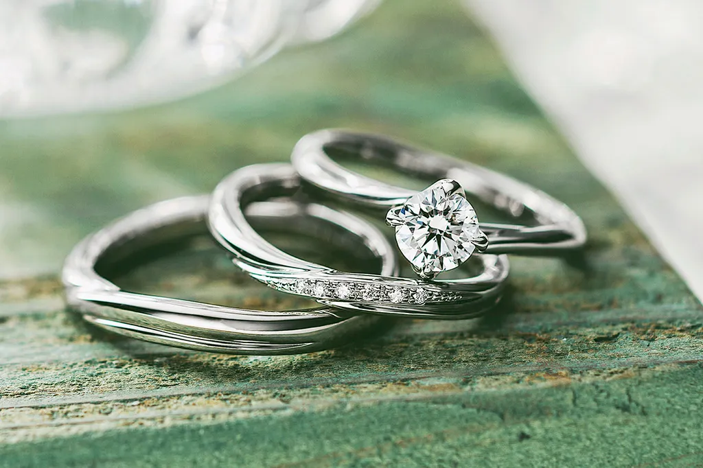 Three silver and diamond engagement rings displayed