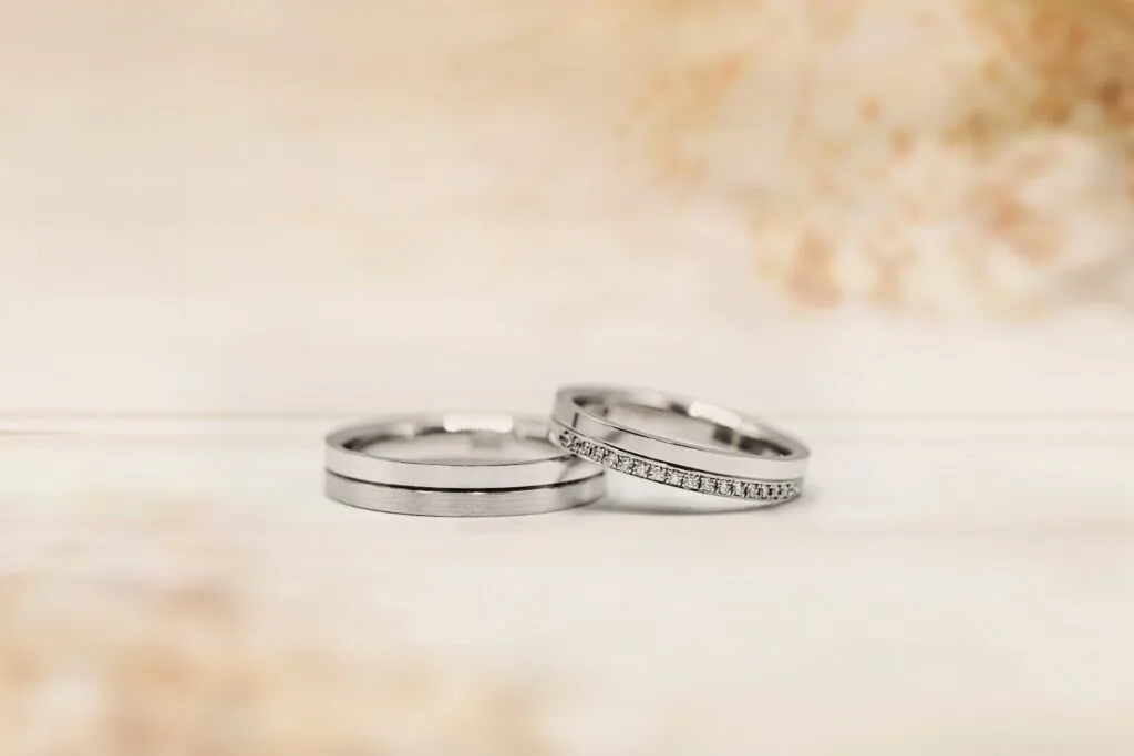 Two elegant silver wedding rings on a soft background.