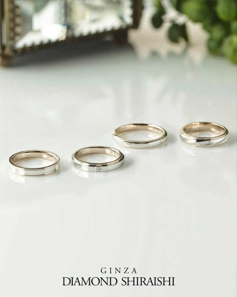 Four elegant silver wedding rings displayed on a table.