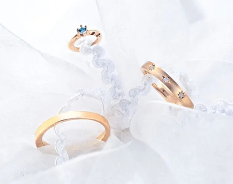 Three elegant rings on delicate fabric.